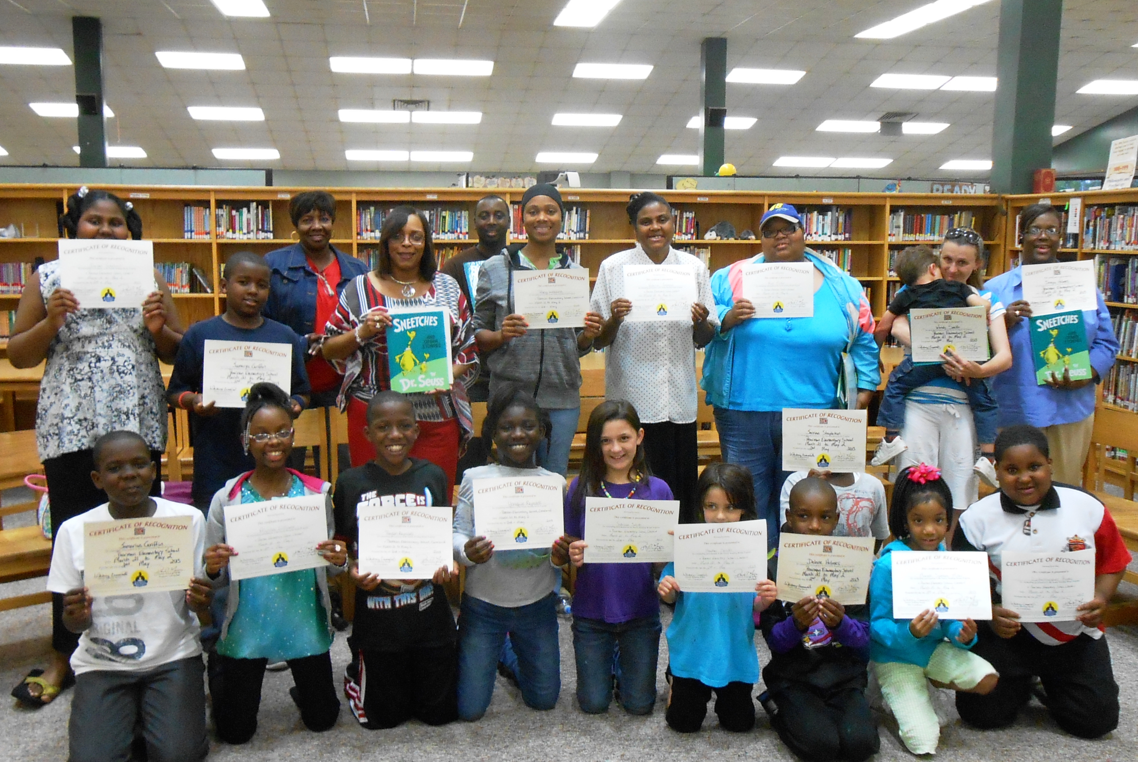 Graduates of the Family Reading Bonds program proudly display their gift books and certificates of completion. 